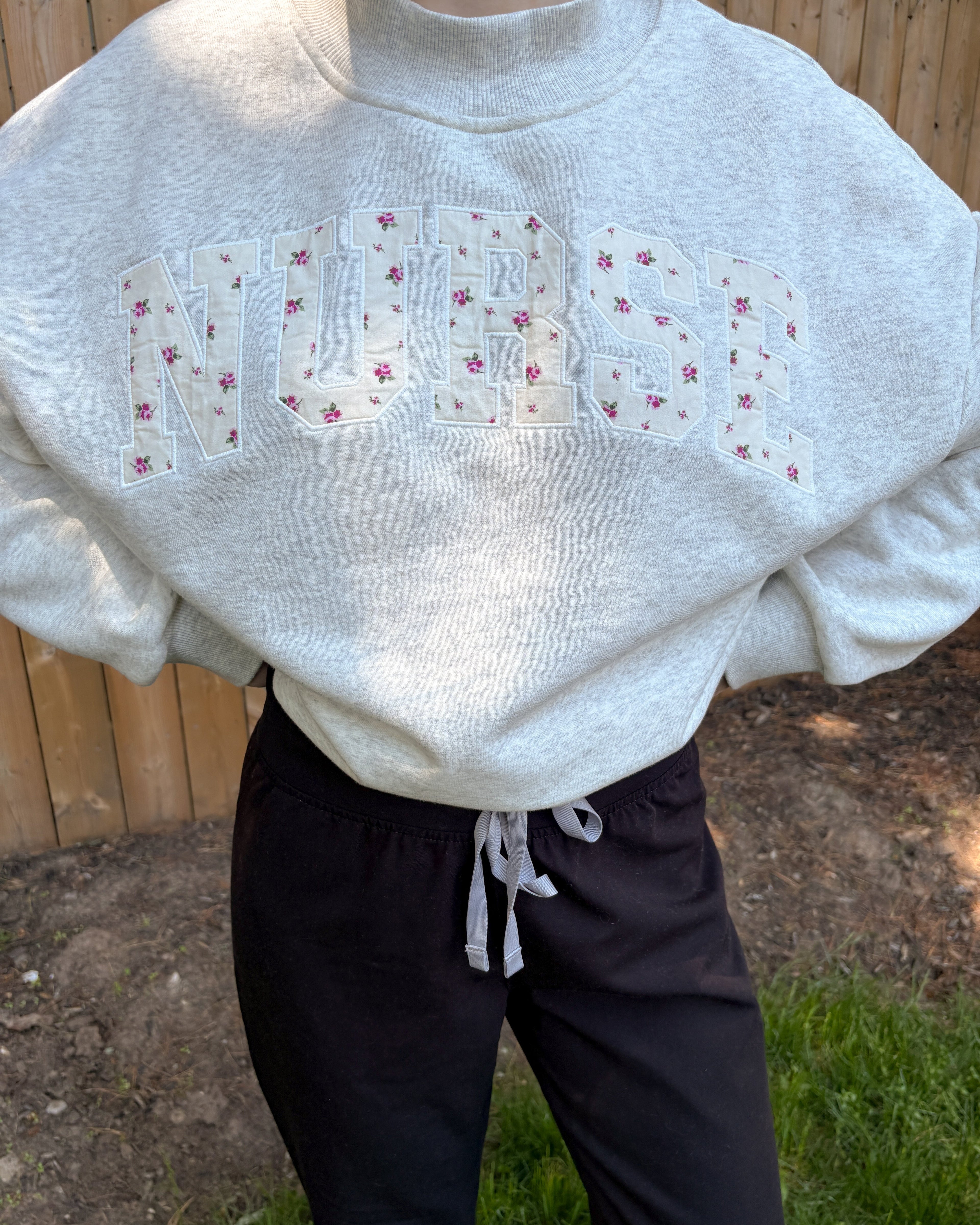 Grey mock neck sweatshirt with floral appliqué embroidery 'nurse'